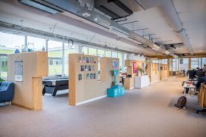 Moderne kantoorruimte aan de Helmholtzstraat met open werkplekken, speelhoek en decoratieve wanden.