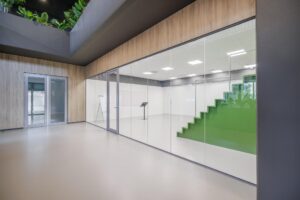 Moderne kantoorruimte aan de Helmholtzstraat met glazen wanden en een groene traptribune in het interieur.