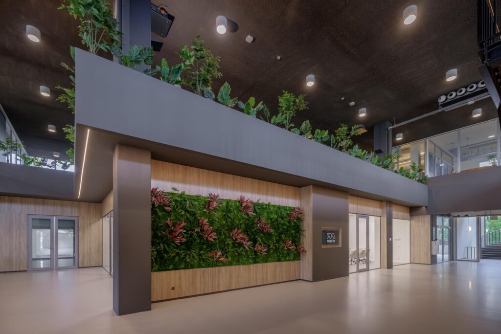 Moderne kantoorhal aan de Helmholtzstraat met groene gevel en planten op de verdieping.