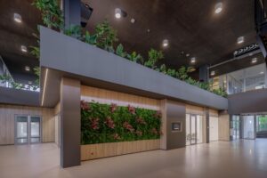 Moderne kantoorhal aan de Helmholtzstraat met groene gevel en planten op de verdieping.