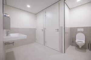 Moderne, goed verlichte toiletruimte met wandcloset, wastafel en twee afgesloten deuren in Helmholtzstraat.