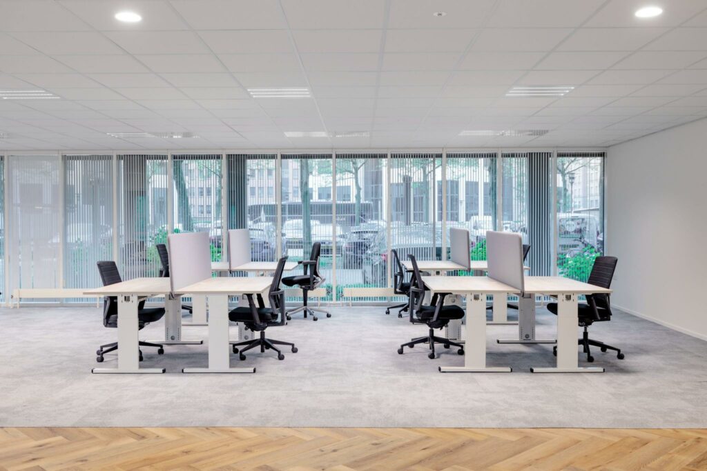 Moderne, open kantoorruimte aan de Hullenbergweg met verstelbare bureaus en ergonomische bureaustoelen.