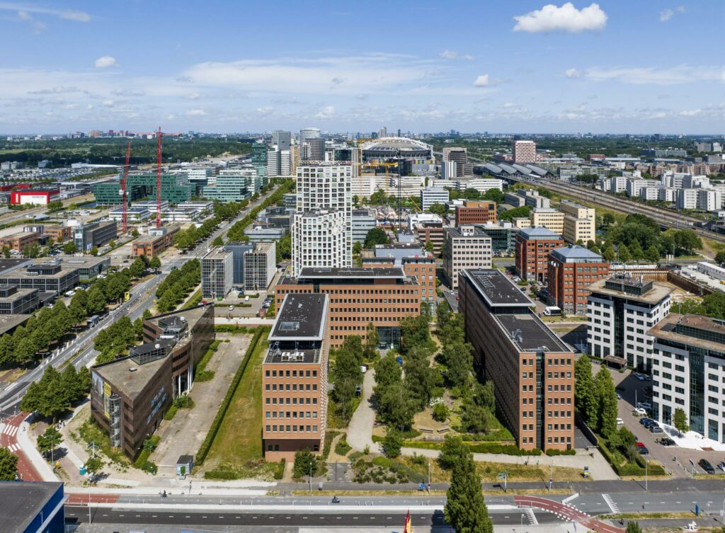 Luchtfoto van kantoren en bebouwing aan de Hullenbergweg in Amsterdam-Zuidoost met op de achtergrond de Johan Cruijff ArenA.