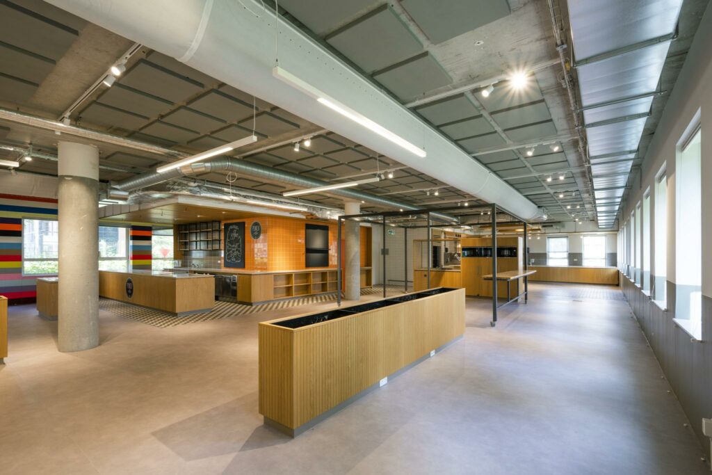Moderne bedrijfskeuken aan de Hullenbergweg met houten afwerking en industriële plafonddetails.