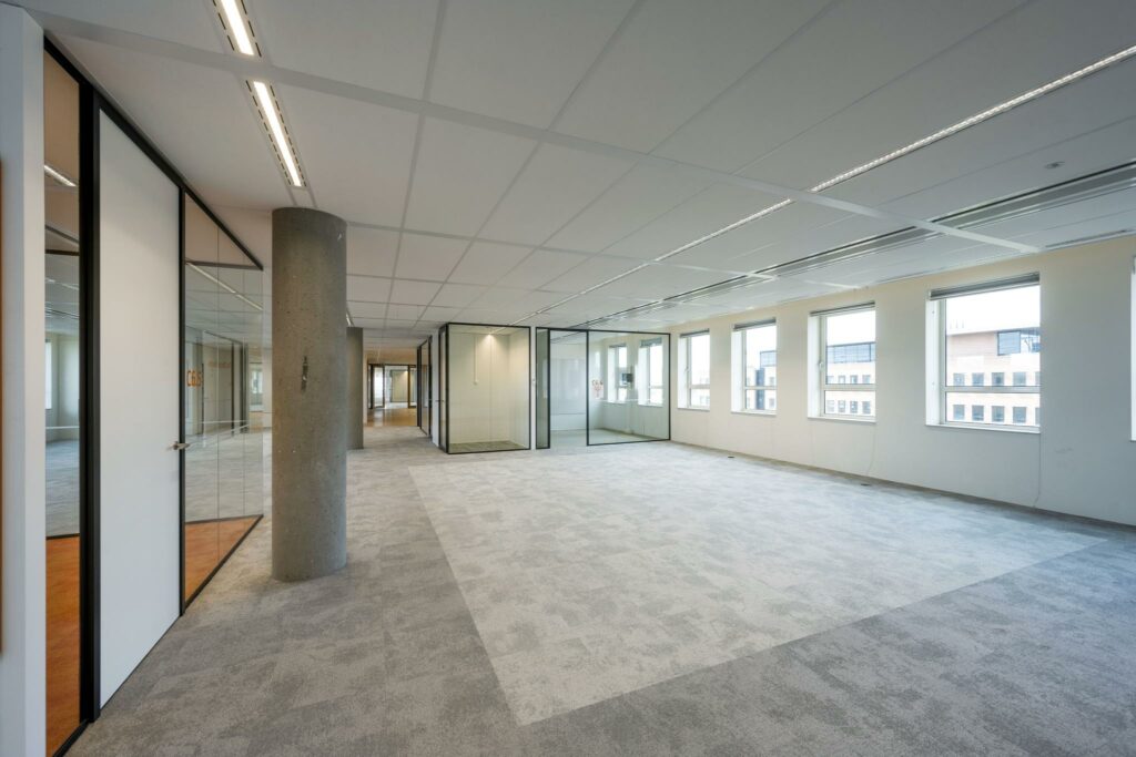 Ruime, moderne kantoorruimte aan de Hullenbergweg met grote ramen en glazen vergaderruimtes.