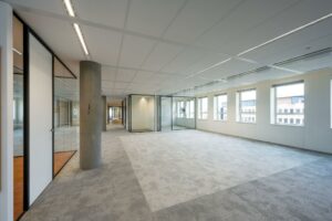 Ruime, moderne kantoorruimte aan de Hullenbergweg met grote ramen en glazen vergaderruimtes.