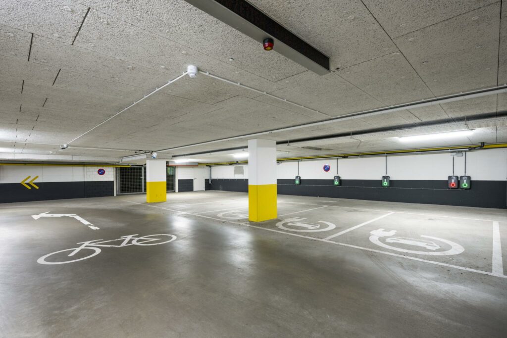 Ondergrondse parkeergarage aan de Hullenbergweg met oplaadpunten voor elektrische auto's en gemarkeerde parkeerplaatsen.