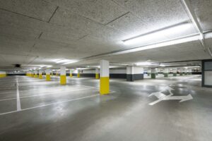 Ondergrondse en goed verlichte parkeergarage aan de Hullenbergweg met lege parkeerplaatsen en pijlen op de vloer.