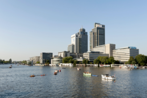 Uitzicht op Amstelplein in Amsterdam met kantoorgebouwen en boten op de rivier.