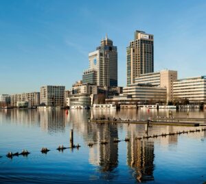 Skyline van Amstelplein in Amsterdam met moderne kantoorgebouwen weerspiegeld in de Amstel.