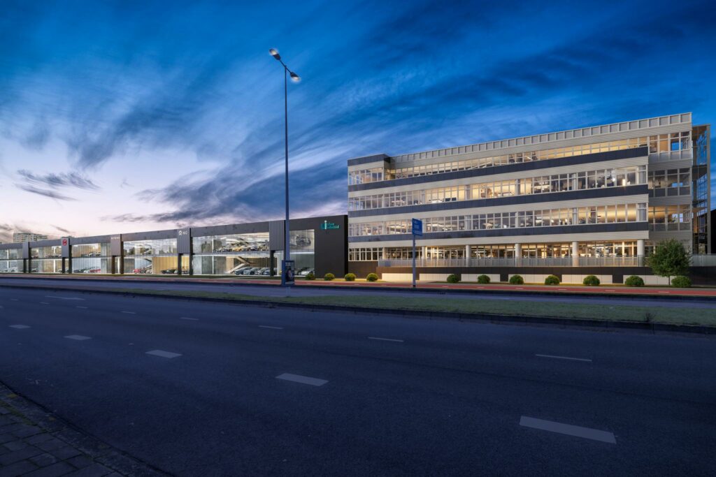 Modern kantoorgebouw en autoshowroom aan de Lemelerbergweg in Amsterdam, gefotografeerd tijdens de schemering.