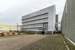 Modern kantoorgebouw aan de Lemelerbergweg 31a met glazen gevel en metalen trappen aan de voorzijde.