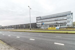 Kantoorgebouw aan de Lemelerbergweg met een "Te Huur"-bord voor circa 2.000 m² kantoorruimte.