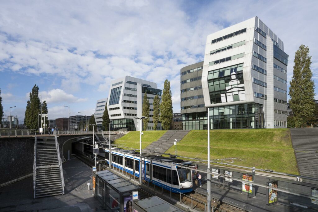 Tramhalte Rietlandpark in Amsterdam met moderne kantoorgebouwen op de achtergrond.
