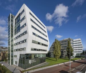 Modern kantoorgebouw van Talpa Network aan het Rietlandpark in Amsterdam, met opvallende witte en grijze gevels en schuin geplaatste ramen.