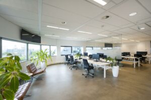Modern en licht kantoorinterieur in Rietlandpark met werkplekken, kantoorstoelen, computers en grote ramen met uitzicht op de stad.