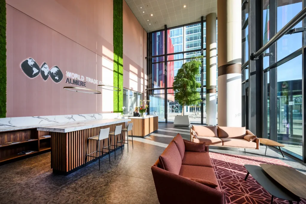Modern lobby of the World Trade Center Almere with large windows, stylish seating, and a reception desk.