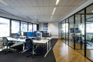 Modern kantoorinterieur aan de Radarweg met werkplekken, glazen vergaderruimtes en uitzicht op de stad.