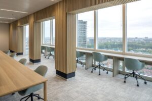 Modern office workspace at Amstelplein with large windows offering a panoramic city view.