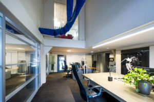 Modern kantoorinterieur aan de Herengracht met open werkplekken, glazen wanden en kunst aan de muur.