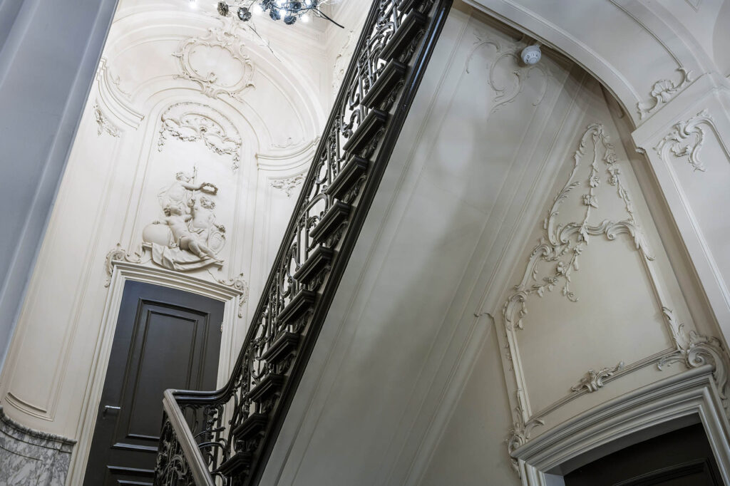 Trapopgang met rijk gedecoreerde stucornamenten en klassiek beeldhouwwerk aan de Herengracht.