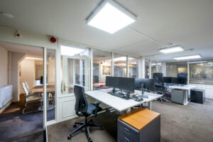 Modern kantoorinterieur aan de Herengracht met werkplekken, glazen wanden en een vergaderruimte.
