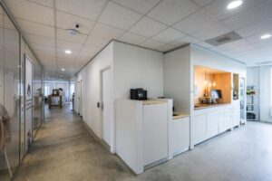 Moderne kantoorruimte aan de Naritaweg met een open gang, glazen wanden en een koffiehoek.