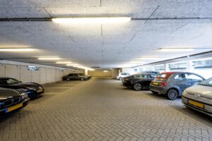 Ondergrondse parkeergarage aan de Naritaweg met geparkeerde auto's aan beide zijden.
