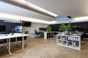 Modern kantoorinterieur aan het Rokin met houten visgraatvloer, open werkplekken en groene kamerplanten.