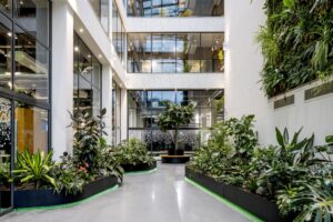 Moderne kantoorruimte aan de Kabelweg met veel groen, grote ramen en een verticale tuin.