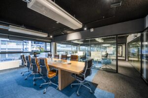 Moderne vergaderruimte aan de Kabelweg met lange houten tafel, lederen stoelen en glazen wanden.