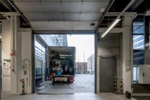 Een vrachtwagen met planten wordt uitgeladen bij een laadperron aan de Kabelweg.