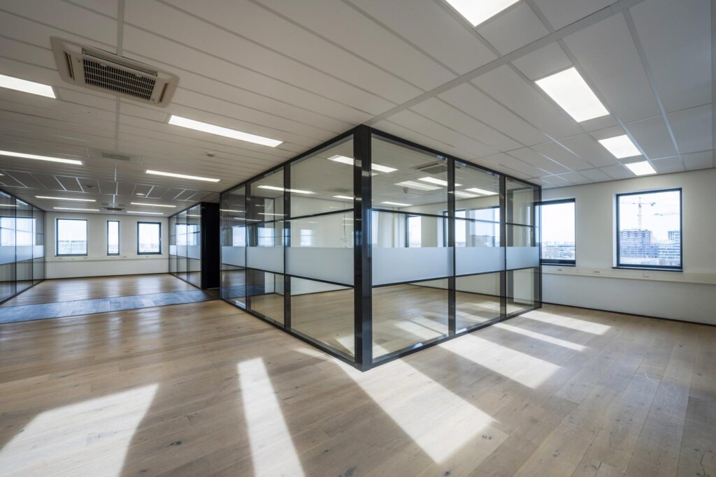 Licht en modern kantoorpand aan de Sijsjesbergweg met glazen scheidingswanden en houten vloer.