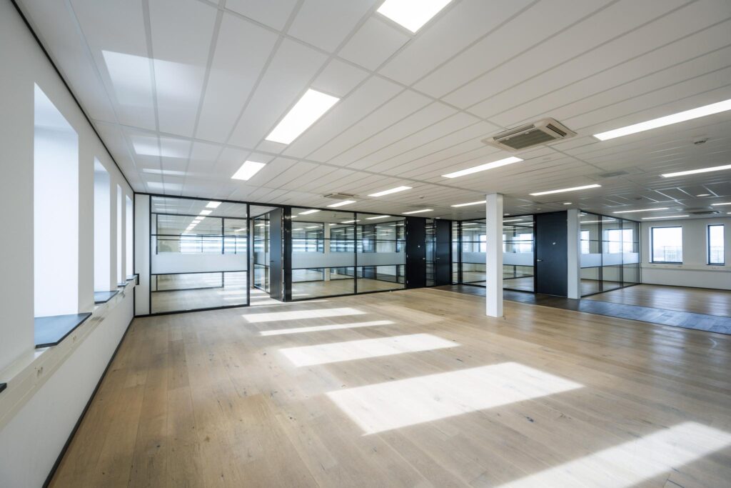 Licht en modern kantoorinterieur aan de Sijsjesbergweg met glazen scheidingswanden en houten vloer.