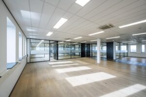 Licht en modern kantoorinterieur aan de Sijsjesbergweg met glazen scheidingswanden en houten vloer.