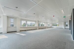 Lichte, ruime en lege kantoorruimte aan de Laarderhoogtweg met grote ramen en tapijtvloer.