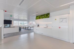Moderne kantoorruimte aan de Laarderhoogtweg met open keuken, zitgedeelte en grote ramen met uitzicht.