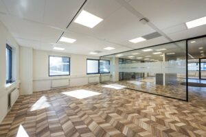 Modern office space on Overschiestraat with geometric wooden flooring and glass partition walls.