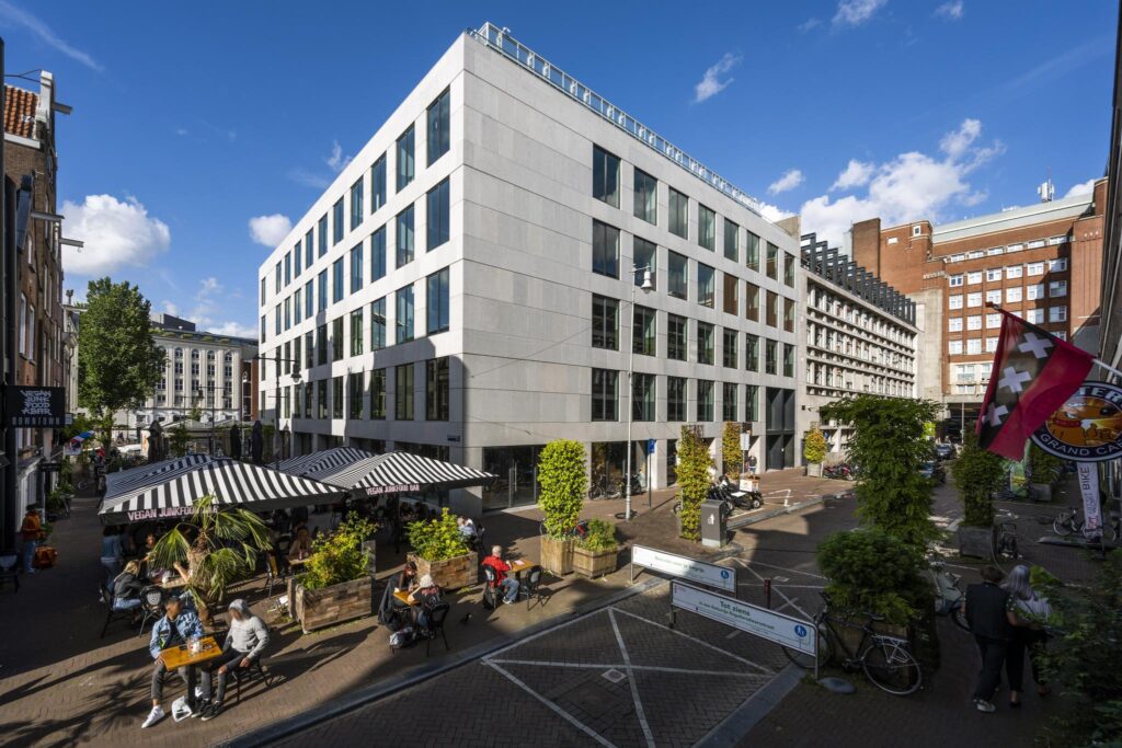 Moderne kantoorgebouwen en terrasjes aan het Singel in Amsterdam op een zonnige dag.