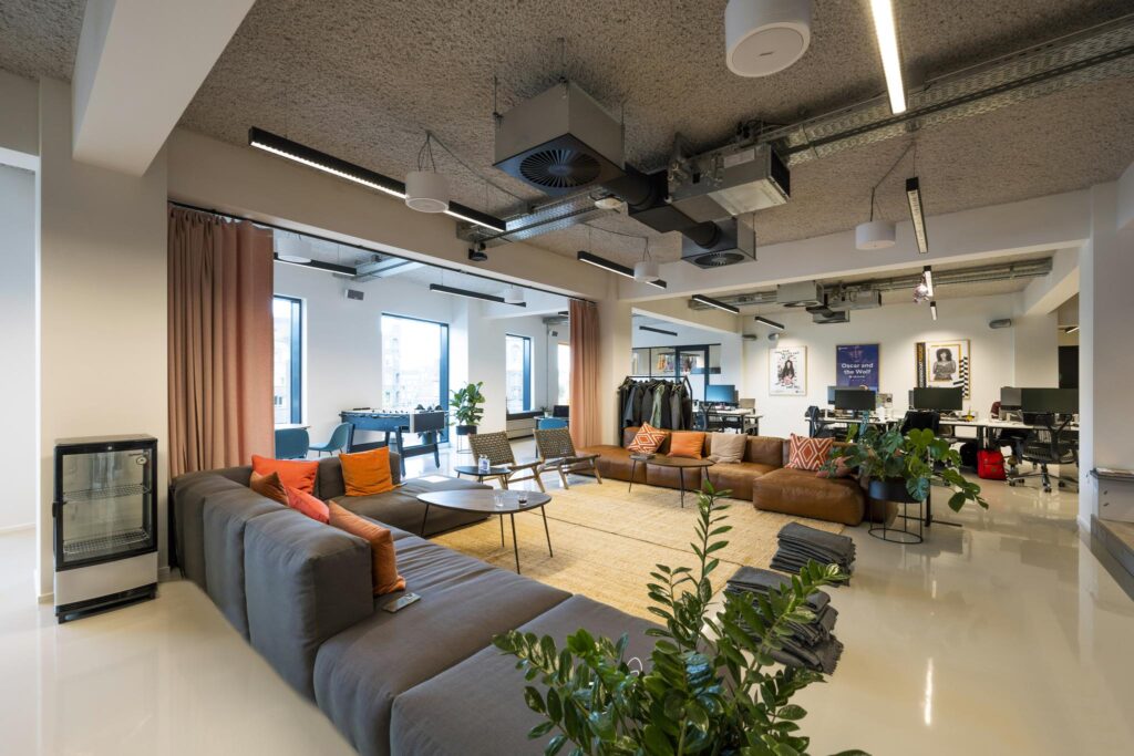 Modern kantoorinterieur aan de Singel met open werkplekken, loungehoek en grote ramen.