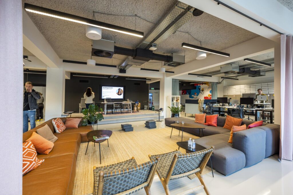 Moderne kantoorruimte aan de Singel met open werkplekken, loungehoek en presentatieruimte.
