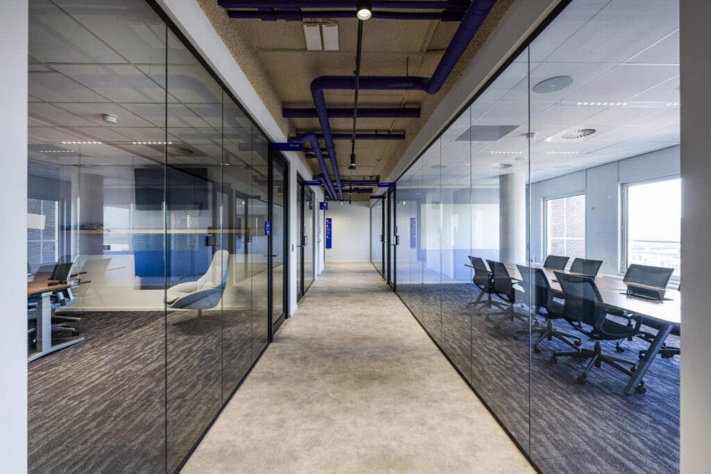Modern office hallway with glass-walled meeting rooms on both sides at Vijzelgracht.