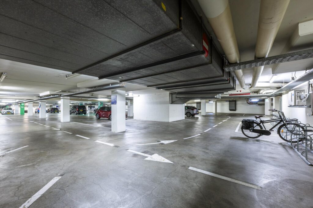 Underground parking garage at Vijzelgracht with parked cars, bicycles, and visible signage.