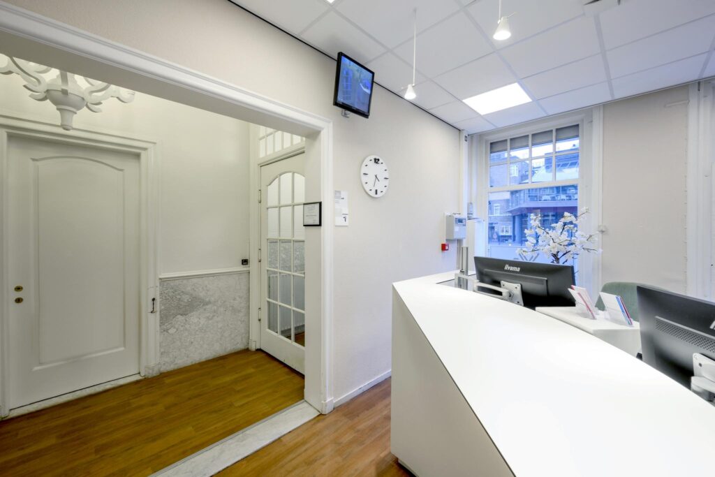 Modern reception area with white furnishings and a window overlooking Concertgebouwplein.
