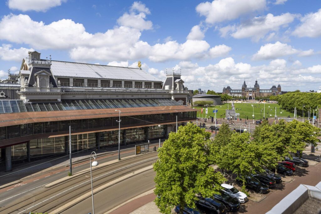 View of the Concertgebouwplein in Amsterdam with the Concertgebouw, Museumplein, and Rijksmuseum in the background on a sunny day.