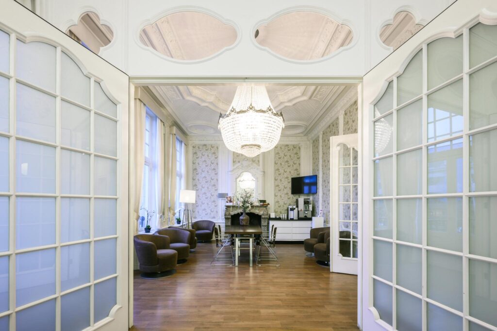 Elegant lounge area with a large chandelier, classic decor, and modern seating at Concertgebouwplein.