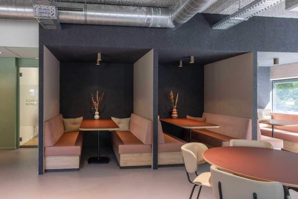 Modern seating area with cozy booths and round tables at Overschiestraat.