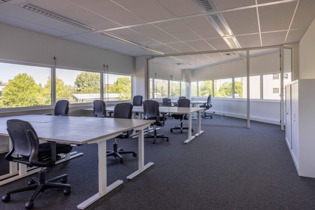 Modern open office space with multiple desks and ergonomic chairs at Overschiestraat.