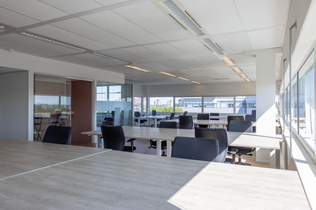Bright and modern open-plan office space at Overschiestraat with multiple desks and chairs.