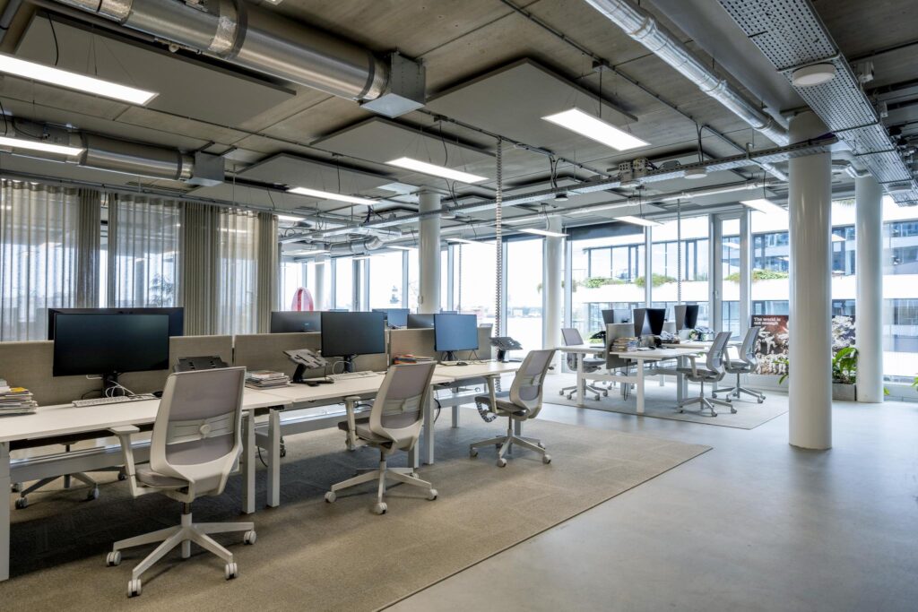 Modern open-plan office interior at Moermanskkade with multiple workstations and large windows.